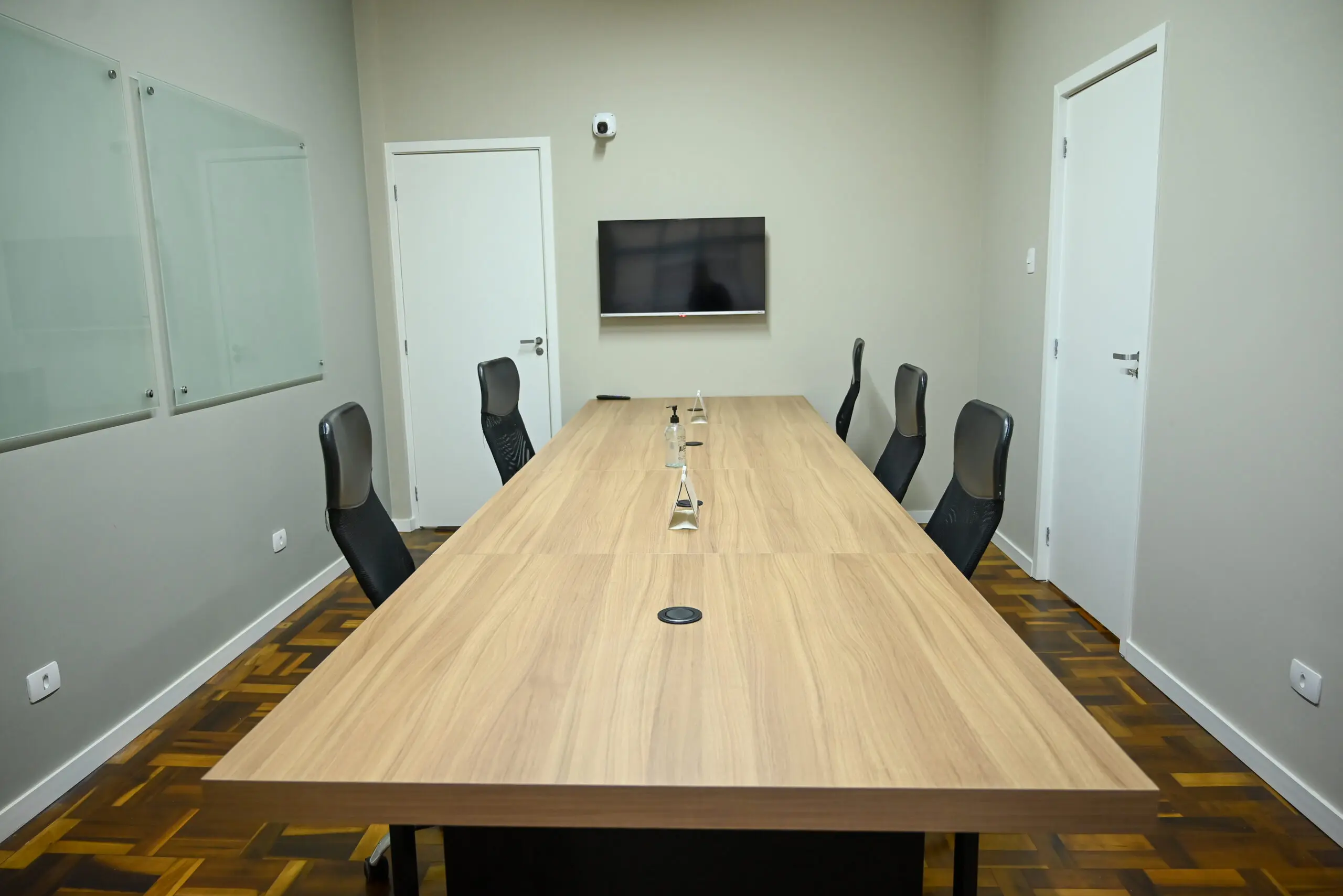Sala de Reunião com TV — Sala de reunião equipada com TV e sistema de som de alta qualidade para apresentações, além de quadros de vidro para trabalho colaborativo. Indicada para alinhamentos internos e recepção de clientes.